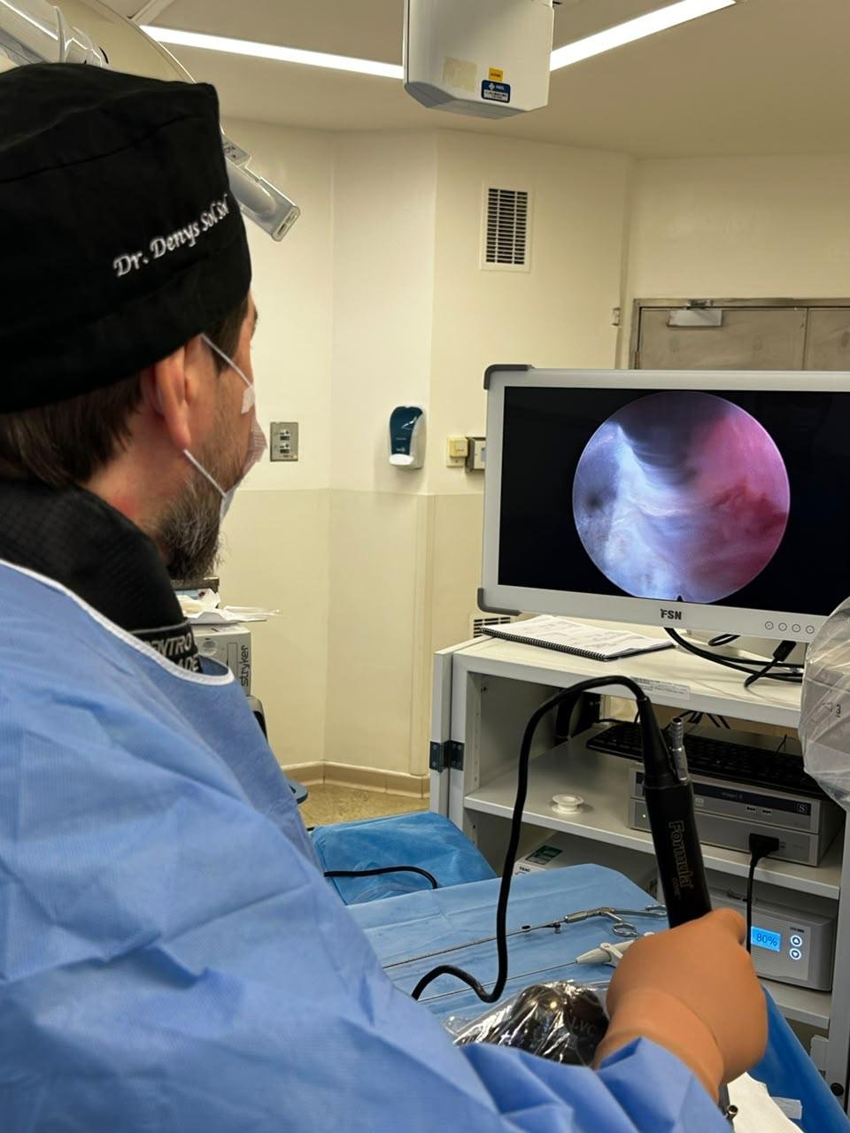 Dr. Denys acompanhando no monitor a imagem da câmera dentro da coluna