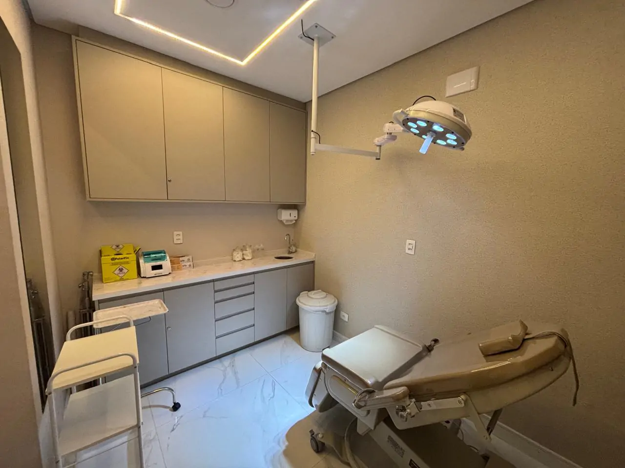 Sala de procedimentos com maca e foco de luz